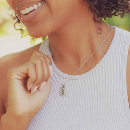 girl holding a pewter May Birth Flower necklace with 18" link chain