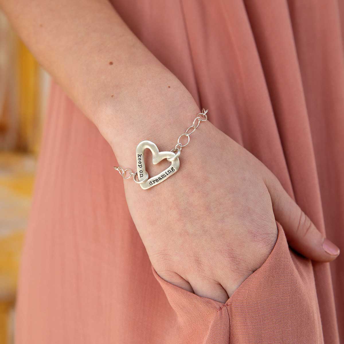 Girl wearing her Personalized sterling silver molded heart bracelet with a freshwater pearl