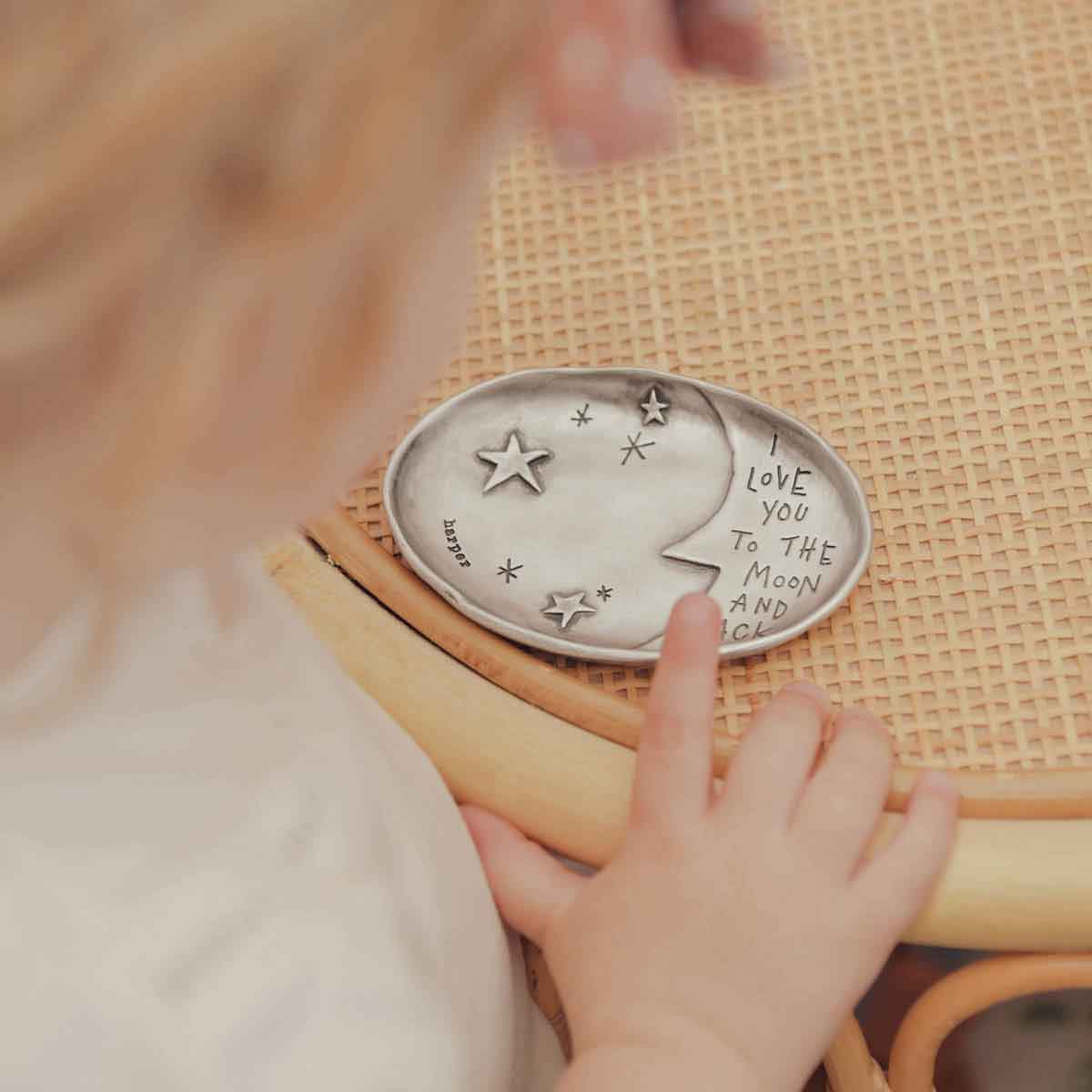 girl holding her personalized moon and back keepsake dish