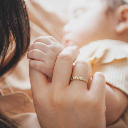 mom wearing her Handcrafted 10k yellow gold mother's rings customizable with up to 6 genuine birthstones along with other gold stacking rings 