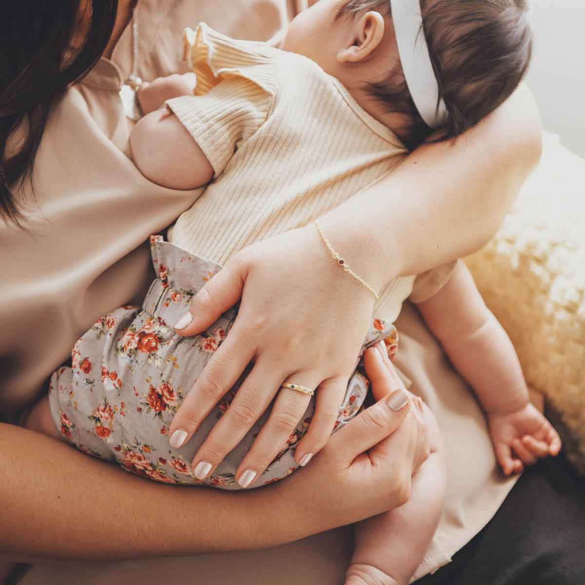 mom wearing her Handcrafted 10k yellow gold mother's rings customizable with up to 6 genuine birthstones along with other gold stacking rings 