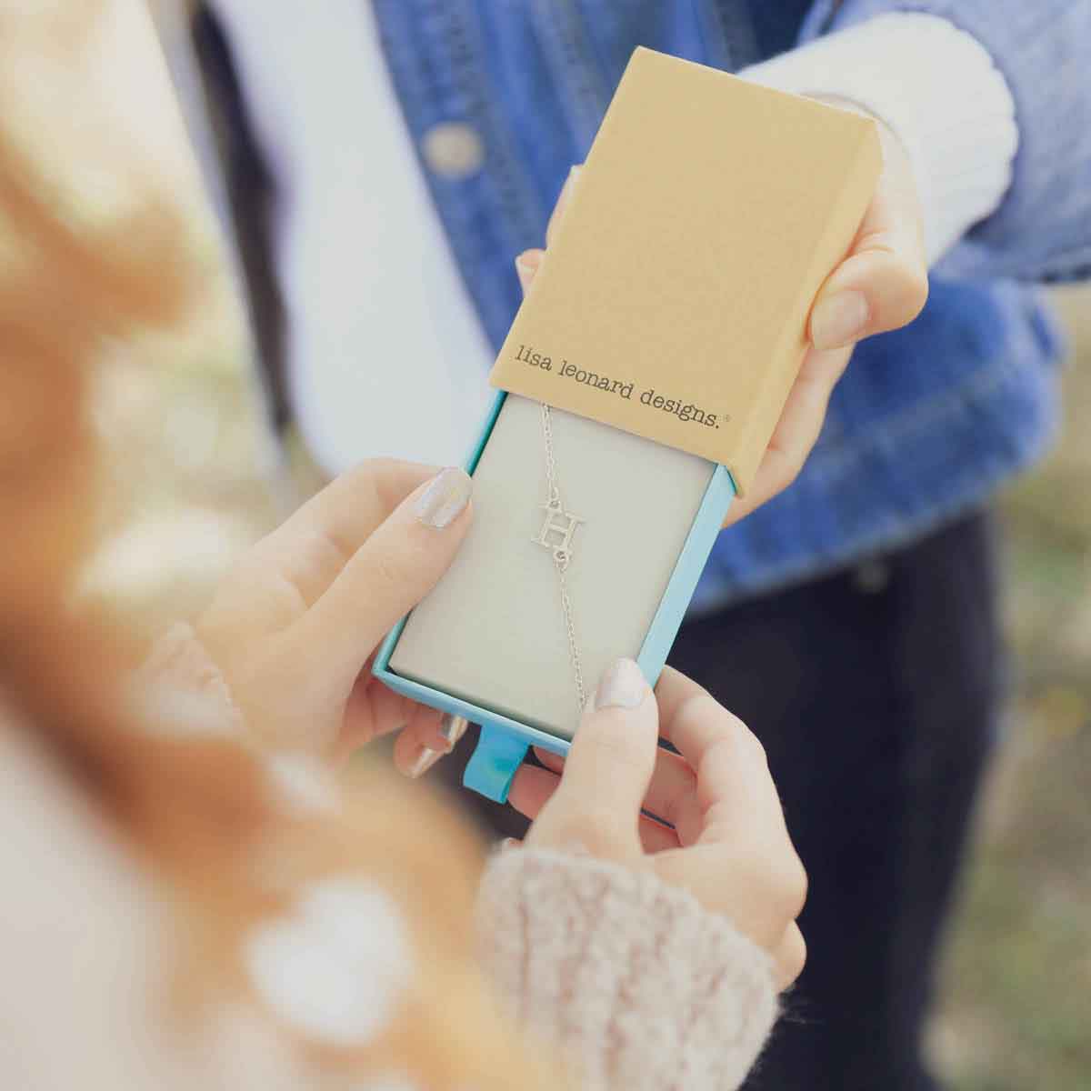 friend giving a Sterling silver monogram bracelet in a lisa leonard box