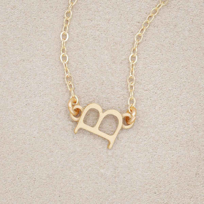 10k yellow gold my monogram letter necklace on beige background