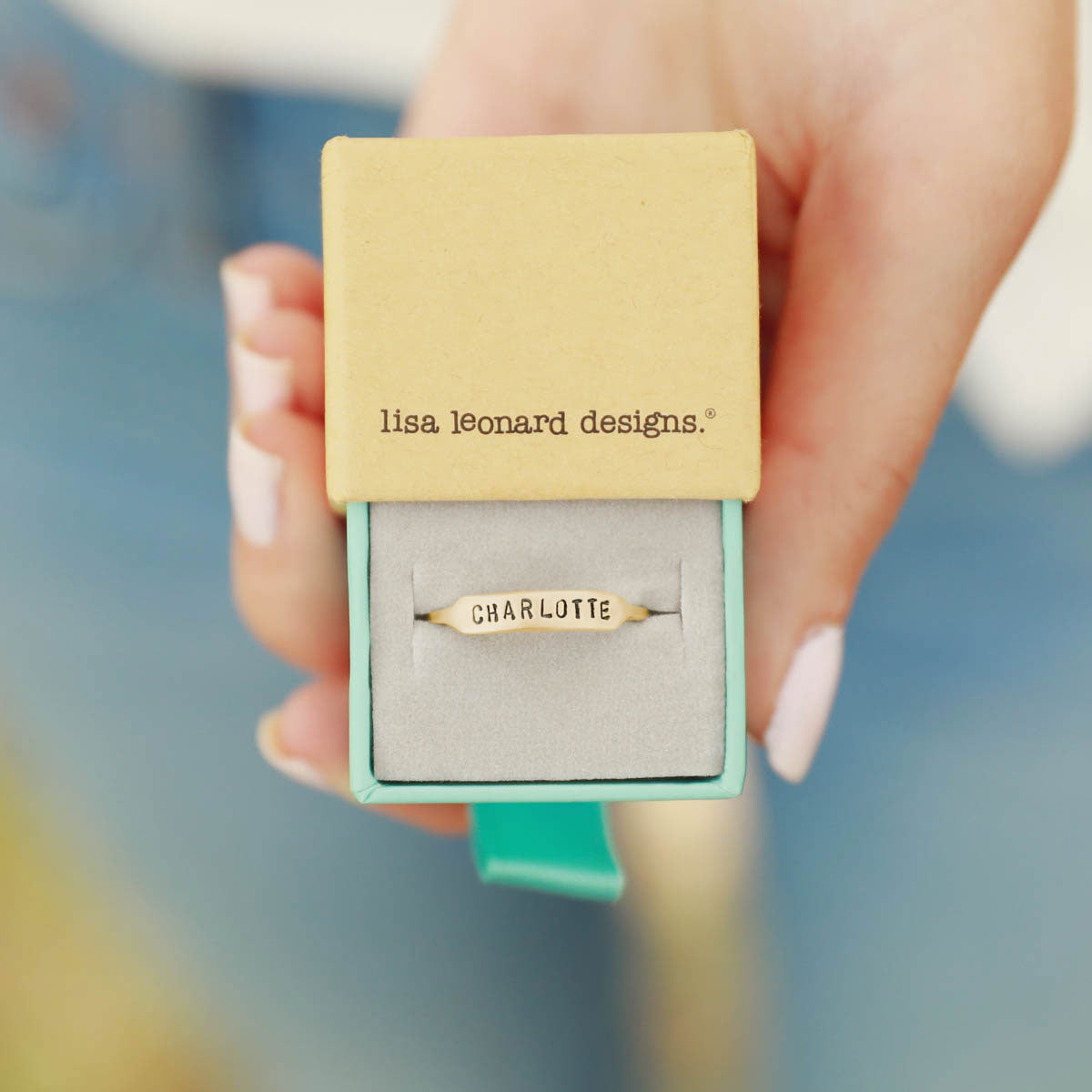 girl holding 10k yellow gold personalized Nameplate Stacking Ring in a lisa leonard ring box