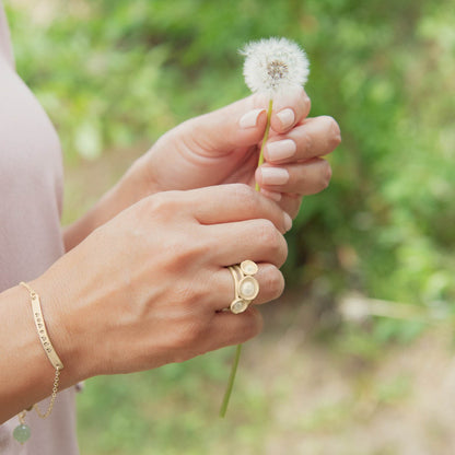 Girl wearing Nesting freshwater large pearl ring hand cast in 10k yellow gold holding inside a large 6mm freshwater pearl 