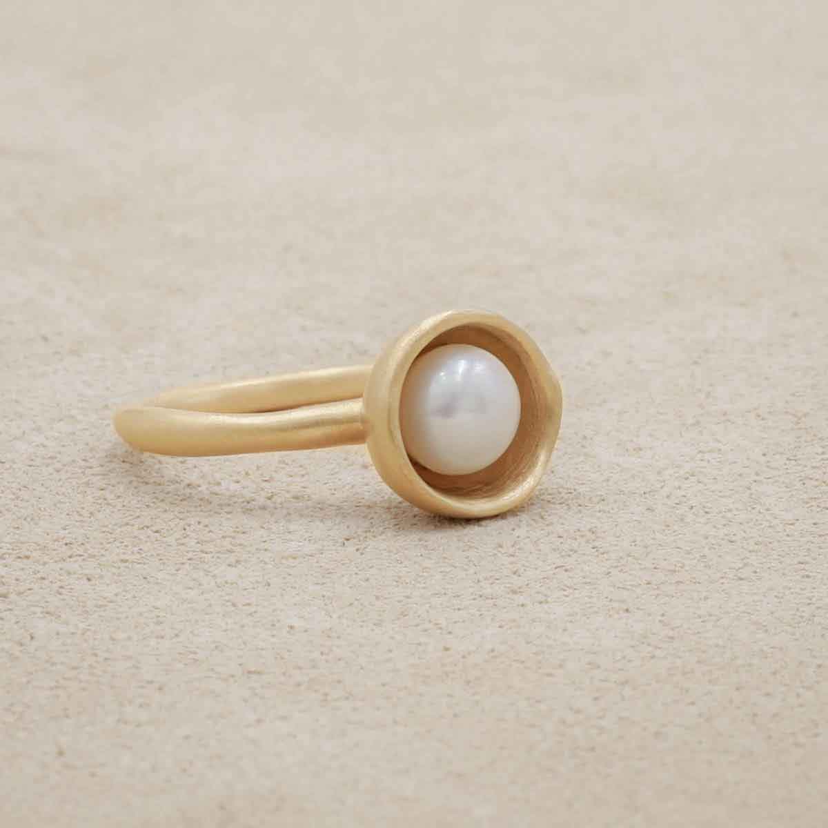 Nesting freshwater large pearl ring hand cast in 10k yellow gold holding inside a large 6mm freshwater pearl