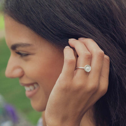 Girl wearing Nesting freshwater large pearl ring hand cast in sterling silver holding inside a large 6mm freshwater pearl 