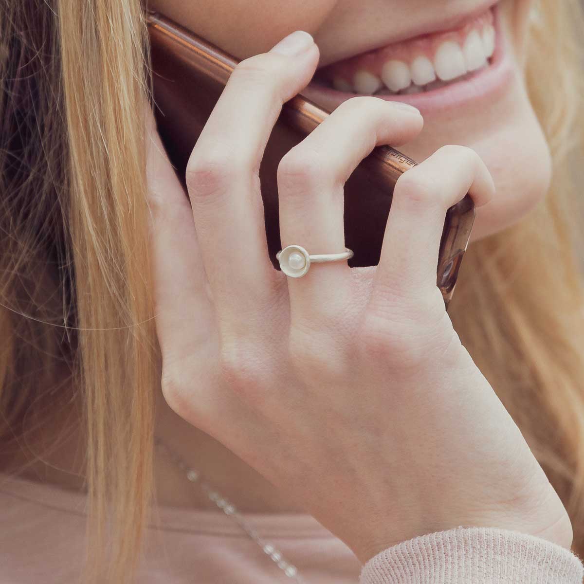 Girl wearing her Nesting freshwater small pearl ring hand cast in sterling silver holding inside a small 4mm freshwater pearl