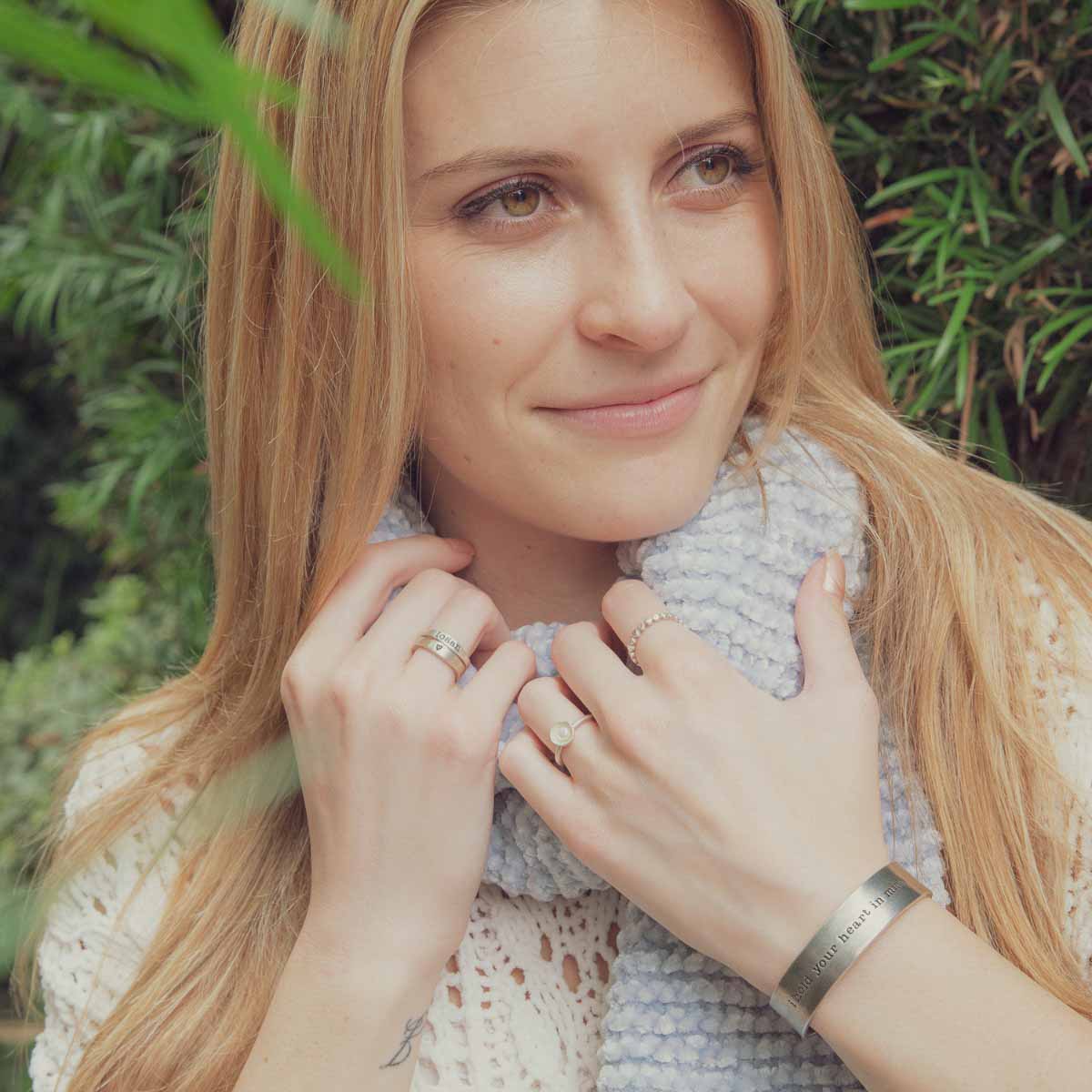 Girl wearing her Nesting freshwater small pearl ring hand cast in sterling silver holding inside a small 4mm freshwater pearl