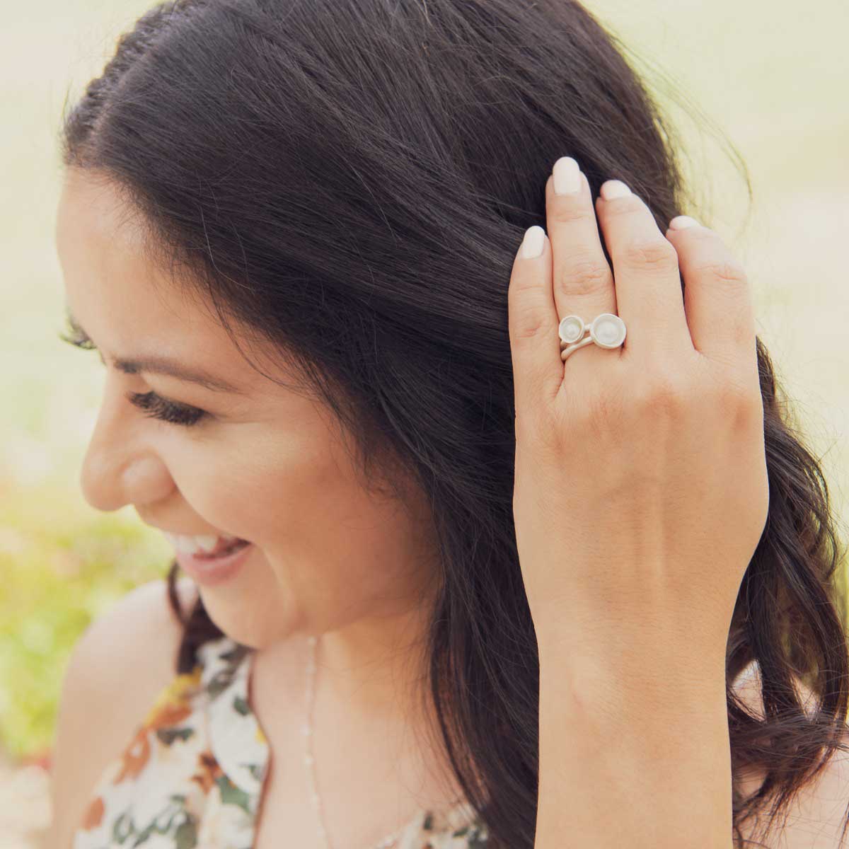 Girl wearing her Nesting freshwater small pearl ring hand cast in sterling silver holding inside a small 4mm freshwater pearl