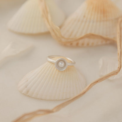 Nesting freshwater small pearl ring hand cast in sterling silver holding inside a small 4mm freshwater pearl