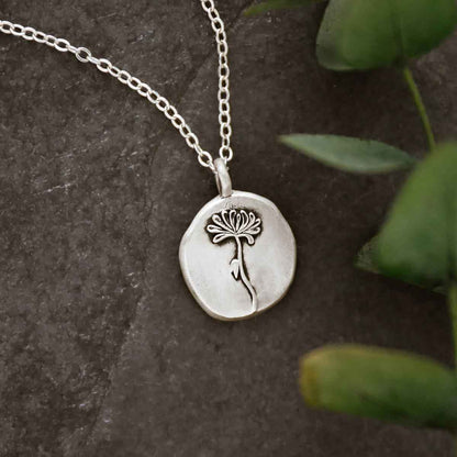 a sterling silver November birth flower necklace on slate background