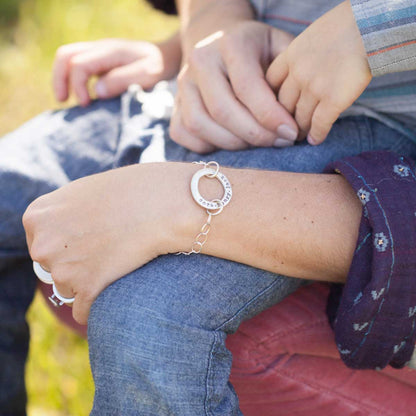 Woman wearing sterling silver open circle pearl bracelet strung on a sterling silver chain