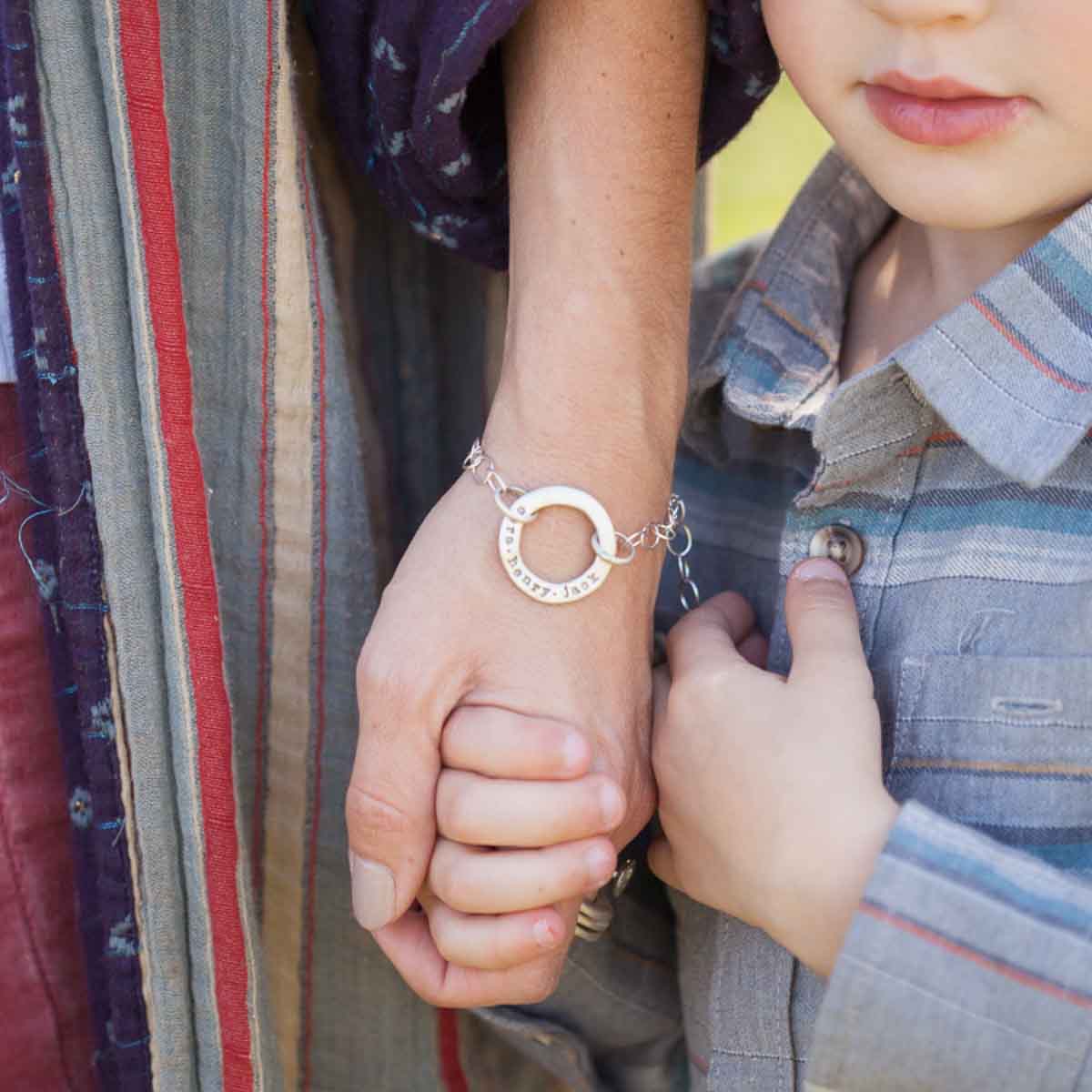 Woman with her son wearing a sterling silver open circle pearl bracelet with a cream freshwater pearl