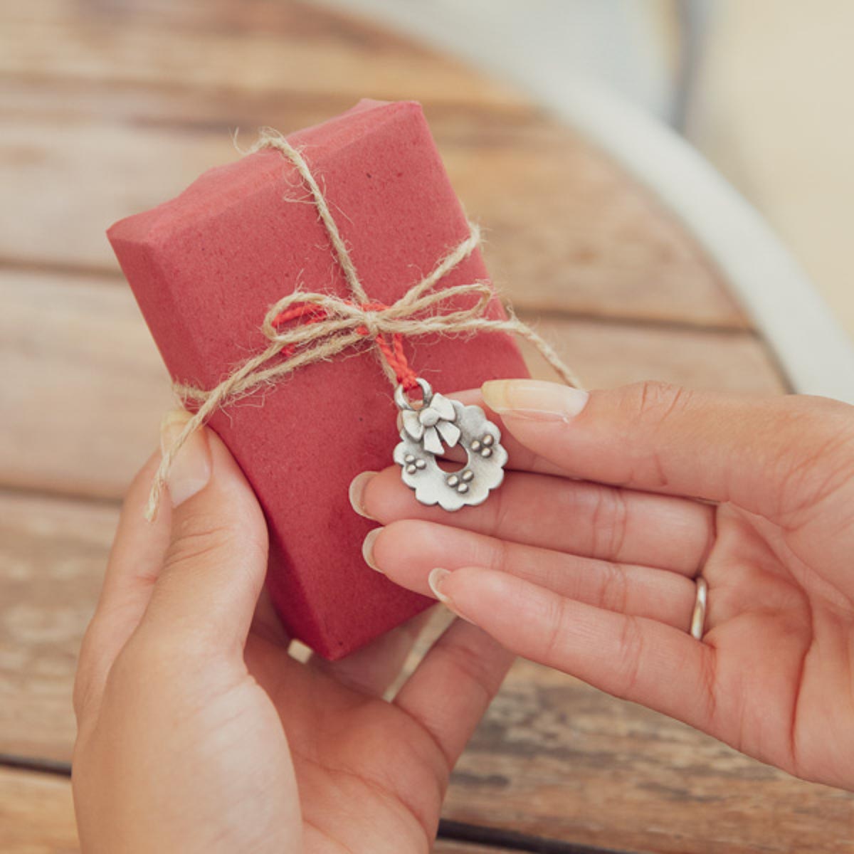 our Christmas tradition advent ornament set handcrafted and cast in fine pewter with one tied around a Christmas present