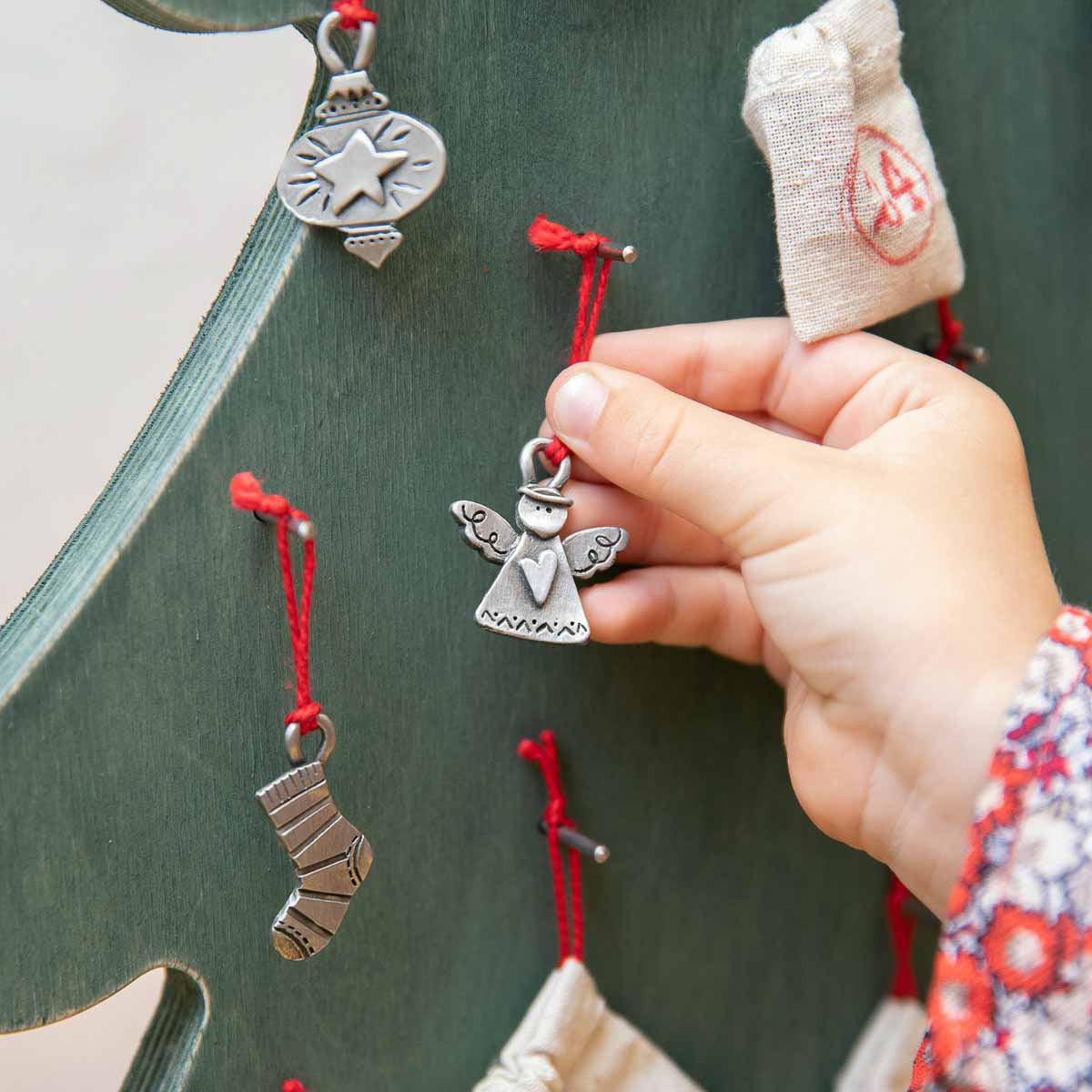 our Christmas tradition advent ornament set handcrafted and cast in fine pewter and includes all 24 ornaments in individual numbered bags hanging on the advent calendar