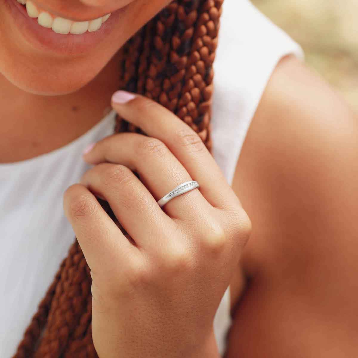 Girl wearing Passage ring handcrafted in sterling silver and display of 1.5mm cubic zirconias 