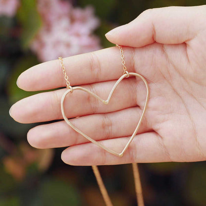 hand holding a Gold filled Peaceful Heart Necklace