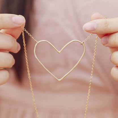 hand holding a Gold filled Peaceful Heart Necklace