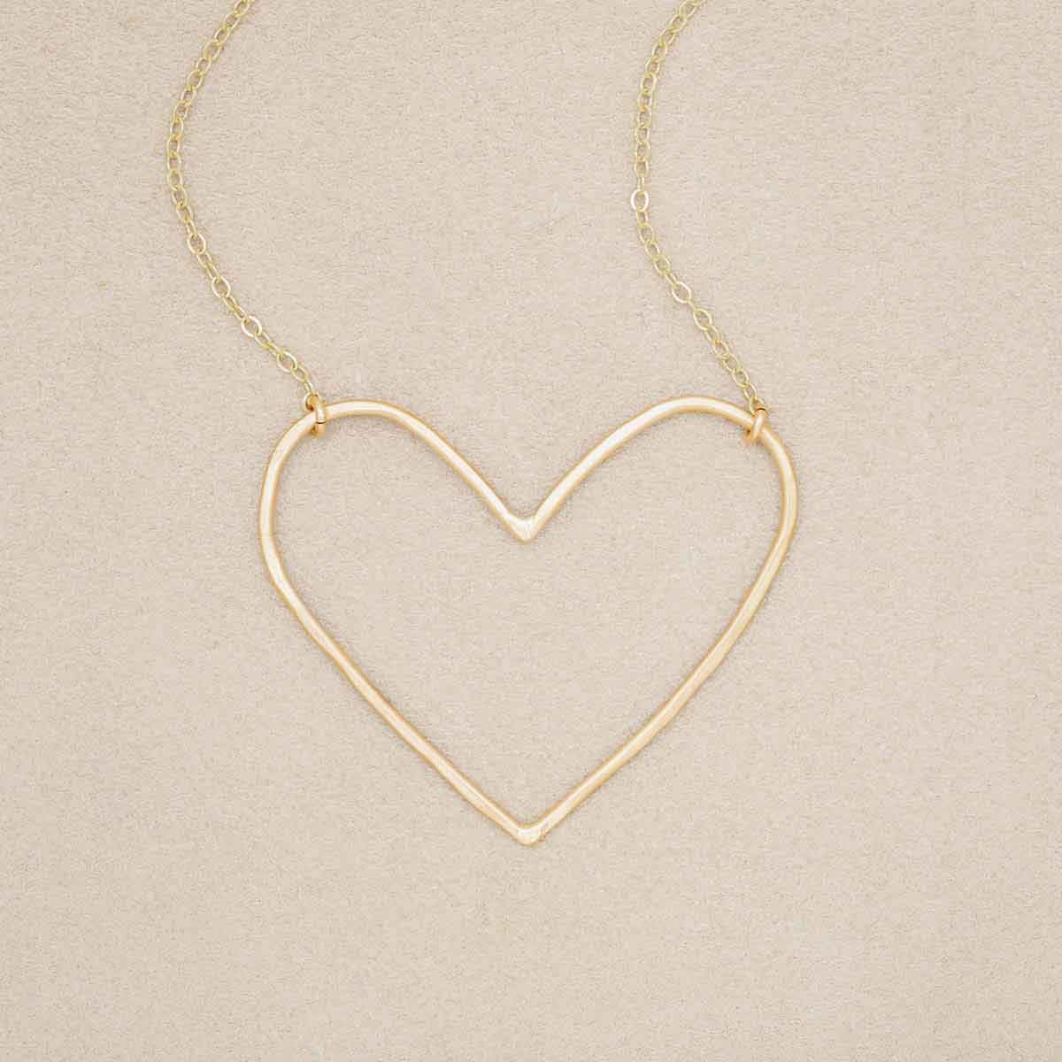 Gold filled Peaceful Heart Necklace on suede background