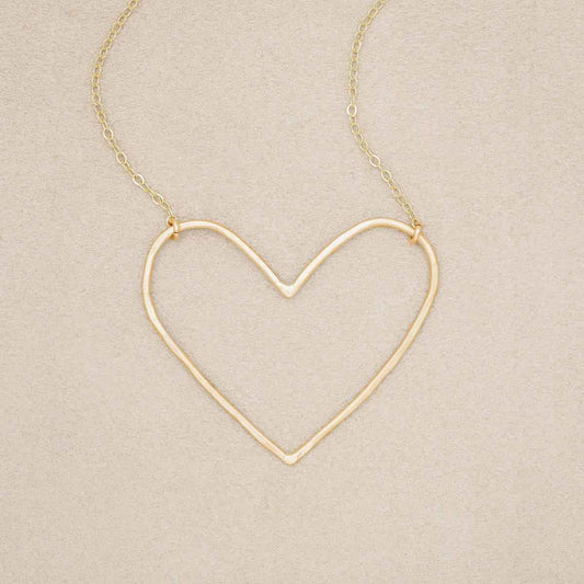 Gold filled Peaceful Heart Necklace on suede background