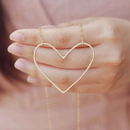 hand holding a Gold filled Peaceful Heart Necklace