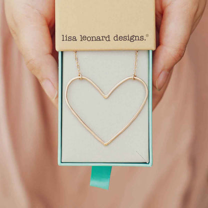 girl holding a Gold filled Peaceful Heart Necklace in a Lisa Leonard necklace box