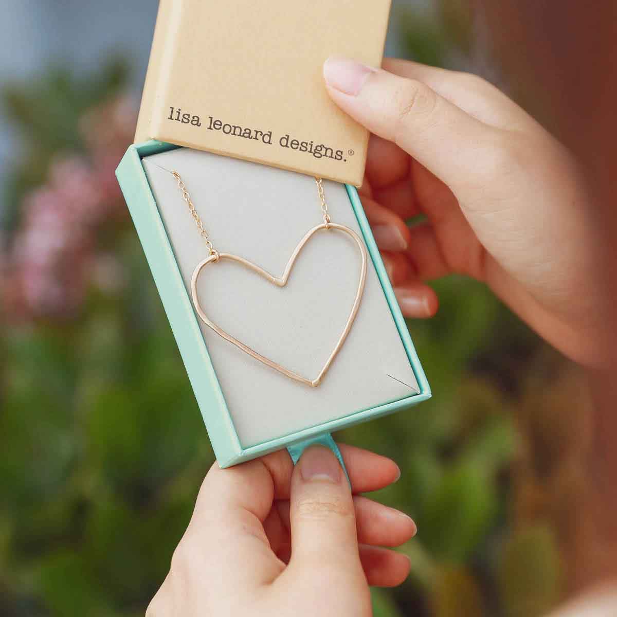 girl holding a Gold filled Peaceful Heart Necklace in a Lisa Leonard necklace box