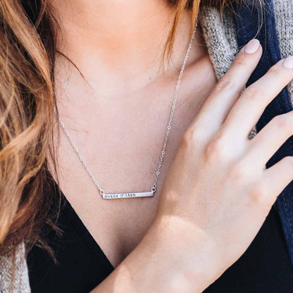 girl wearing sterling silver personalized cross bar necklace customized with name or phrase