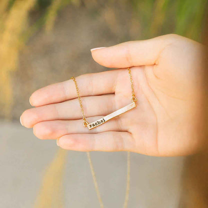 girl wearing a yellow gold personalized cross bar necklace