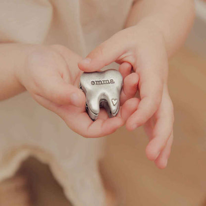 a child holding a Personalized tooth fairy box handcrafted in pewter and hand stamped with their name on it