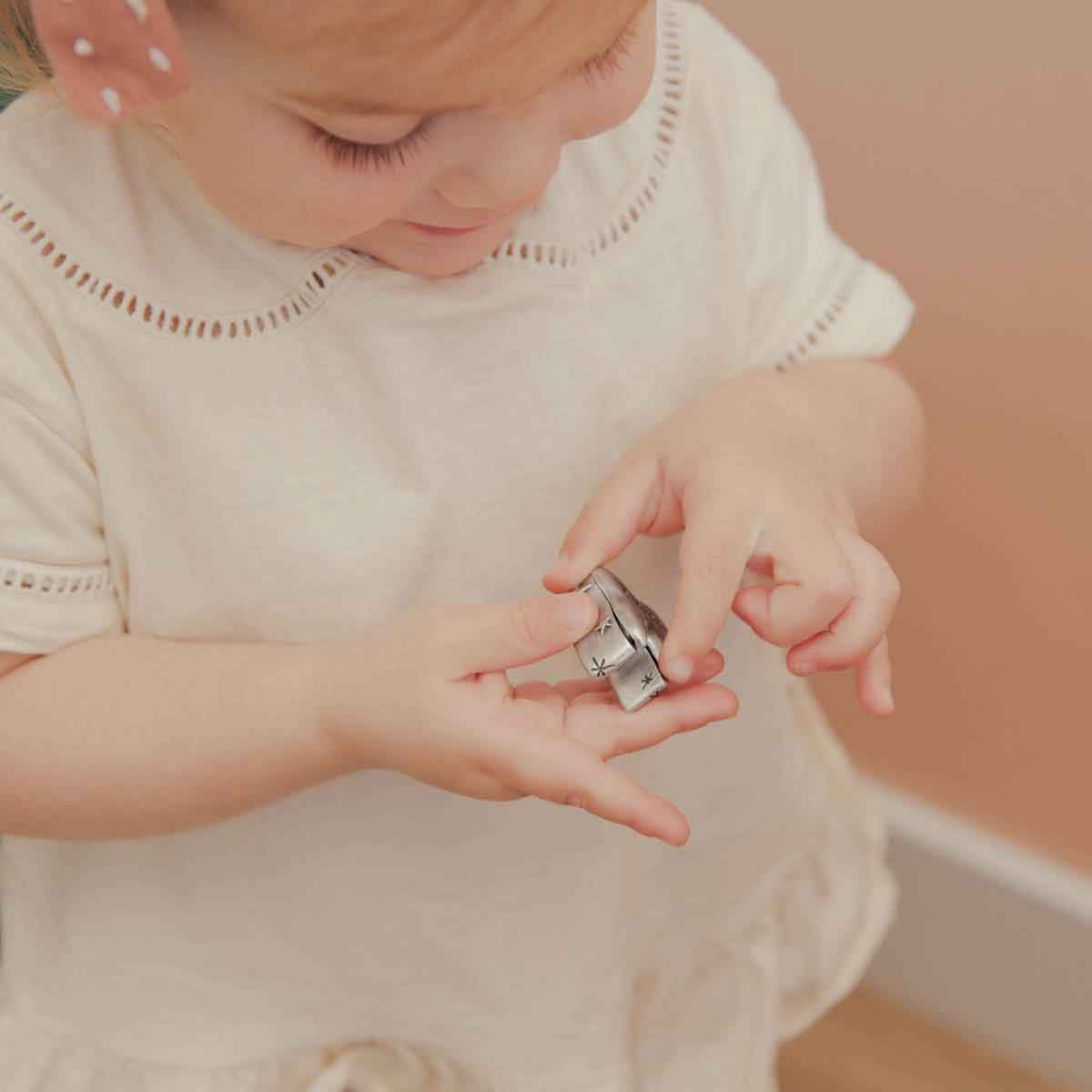 a child holding a Personalized tooth fairy box handcrafted in pewter and hand stamped with their name on it