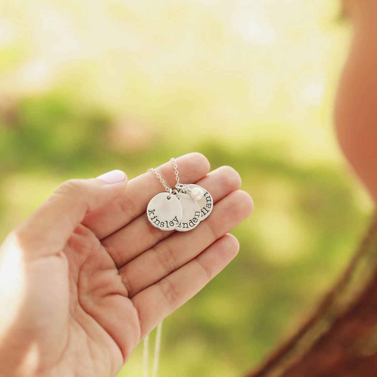 girl wearing sterling silver petite mother's necklace with personalized charms