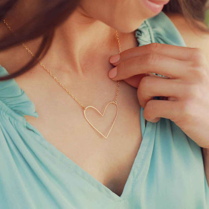 Woman wearing a gold filled Petite Peaceful Heart Necklace