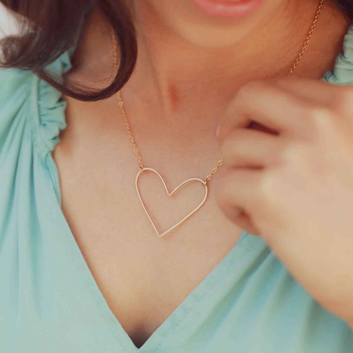 Woman wearing a gold filled Petite Peaceful Heart Necklace