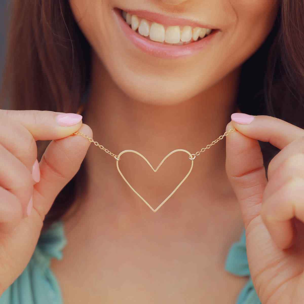 Woman wearing a gold filled Petite Peaceful Heart Necklace