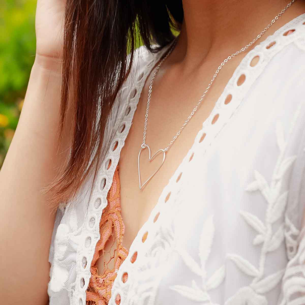 A sterling silver Petite Peaceful Heart Necklace on white dish