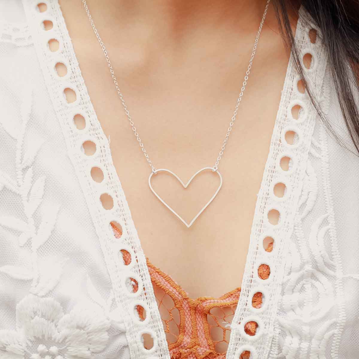 Girl wearing a sterling silver Petite Peaceful Heart Necklace