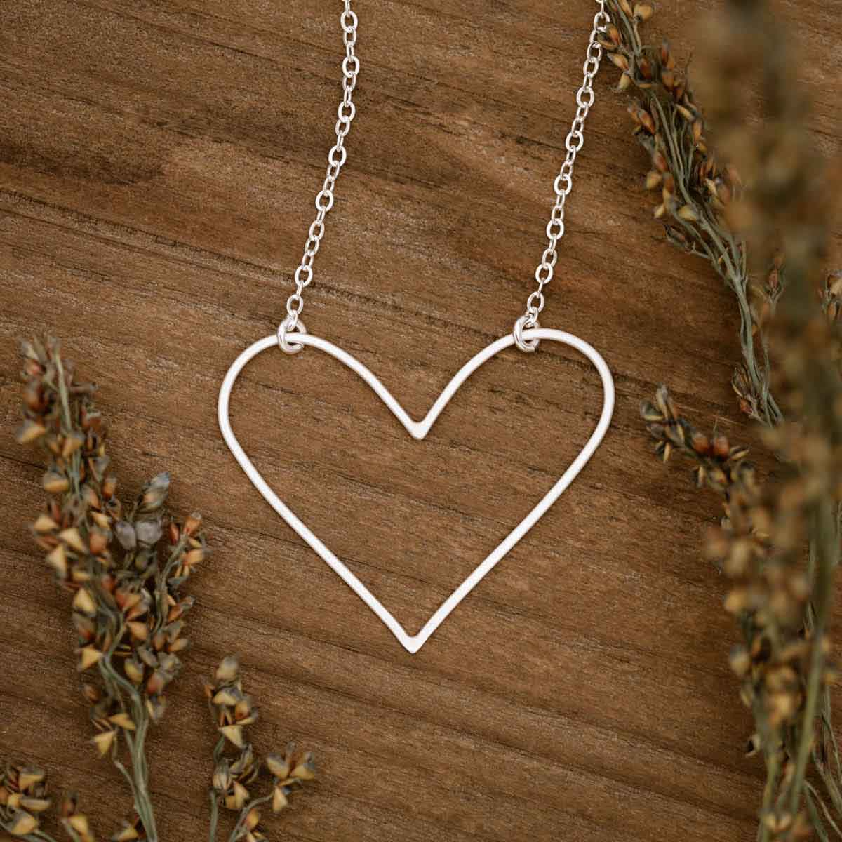 Girl wearing a sterling silver Petite Peaceful Heart Necklace