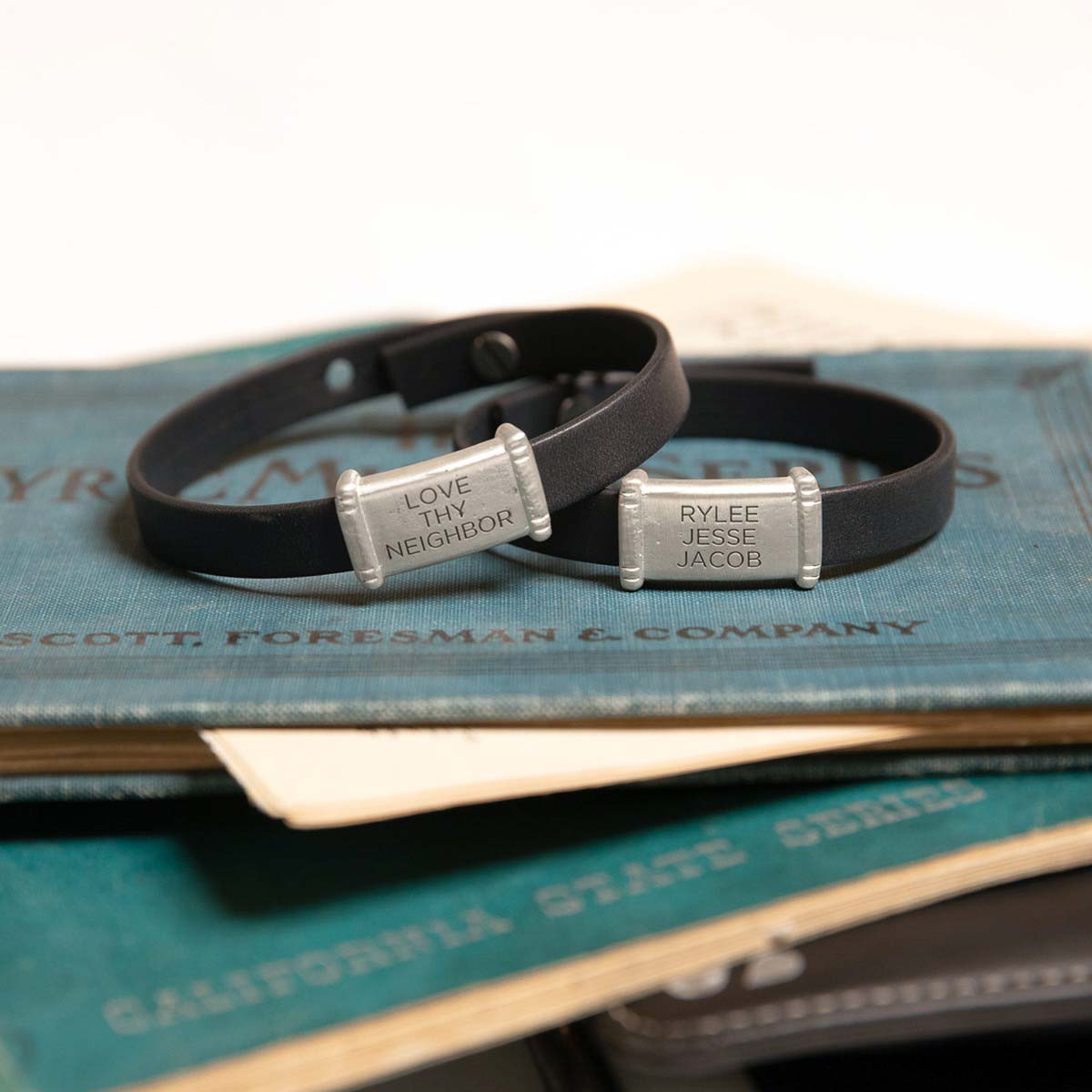 Resolute bracelet handcrafted in black latigo leather with a sterling silver charm and button stud closure and customizable with up to 3 lines