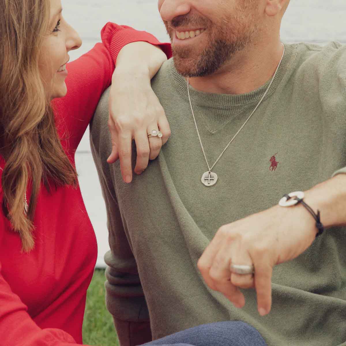 Man wearing Roman Cross Coin necklace handcrafted in sterling silver strung on sterling silver curb chain along with his friend