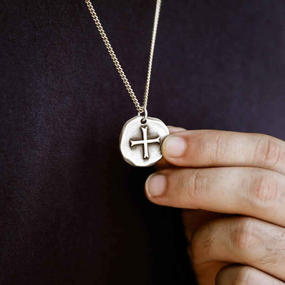 Man wearing Roman Cross Coin necklace handcrafted in sterling silver strung on sterling silver curb chain 