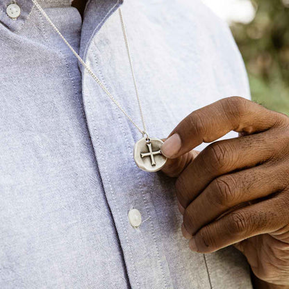 Man wearing Roman Cross Coin necklace handcrafted in sterling silver strung on sterling silver curb chain 