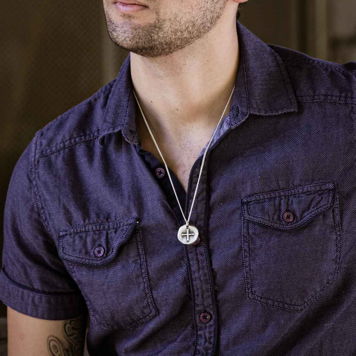 Man wearing Roman Cross Coin necklace handcrafted in sterling silver strung on sterling silver curb chain