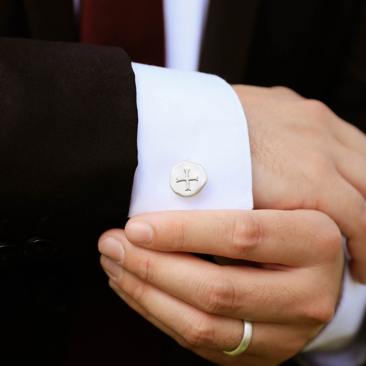 Wedding groom wearing his roman cross cufflinks handcrafted in sterling silver