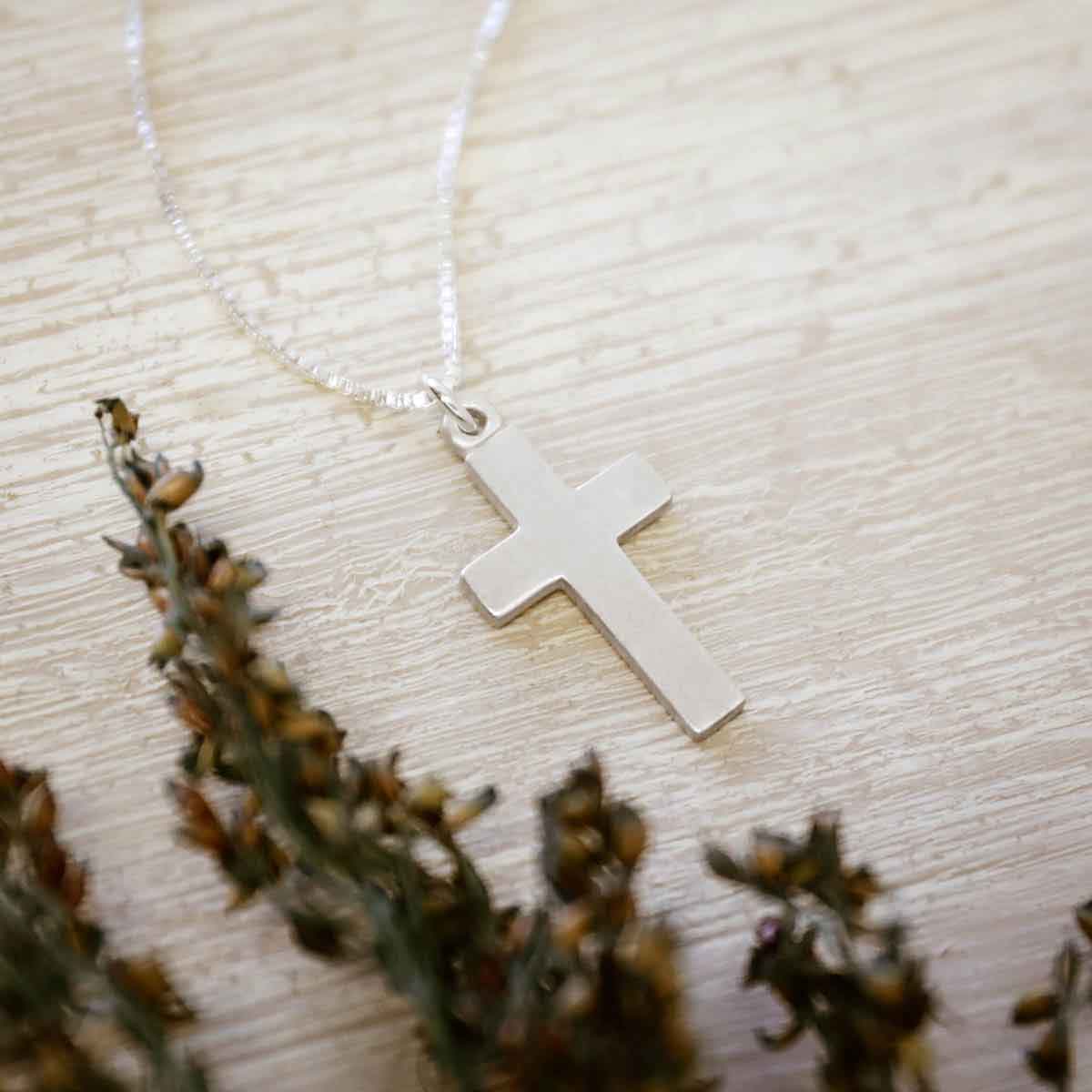 woman wearing a sterling silver Rooted and Grounded Cross necklace