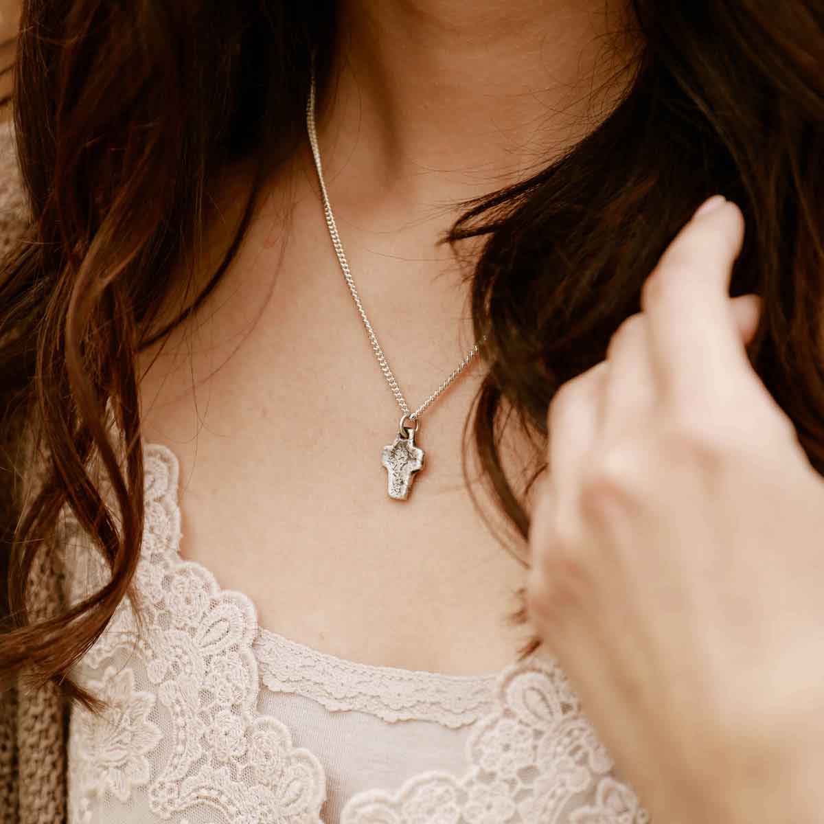 woman wearing a Thrive Cross necklace handcrafted in sterling silver with choice of chain