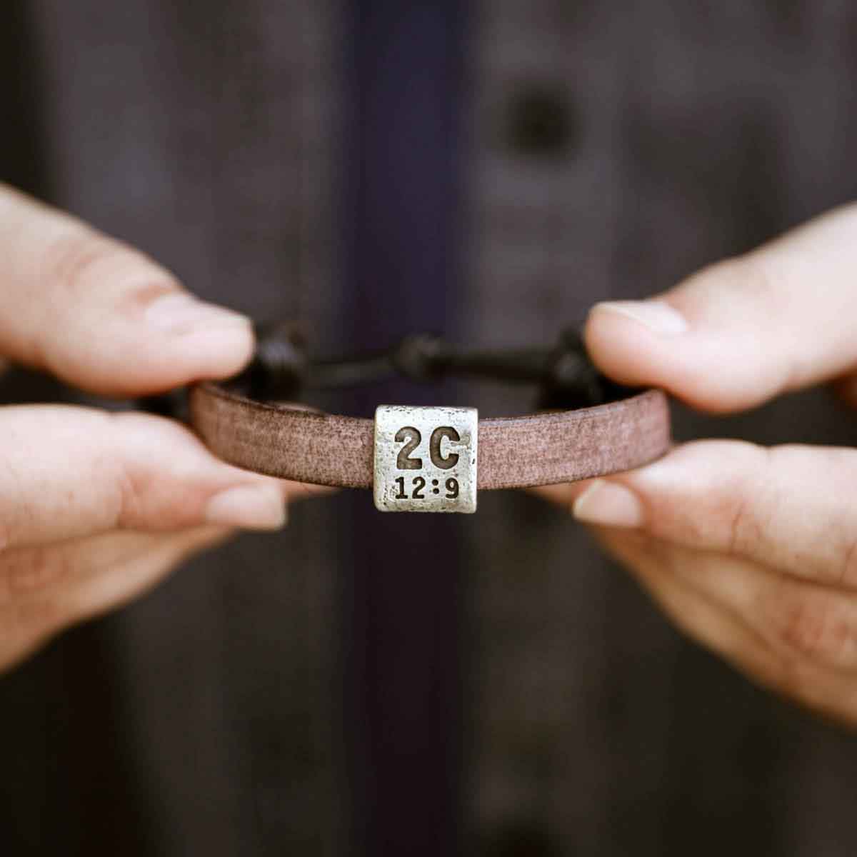 man holding a brown Equitable Leather Verse Bracelet 