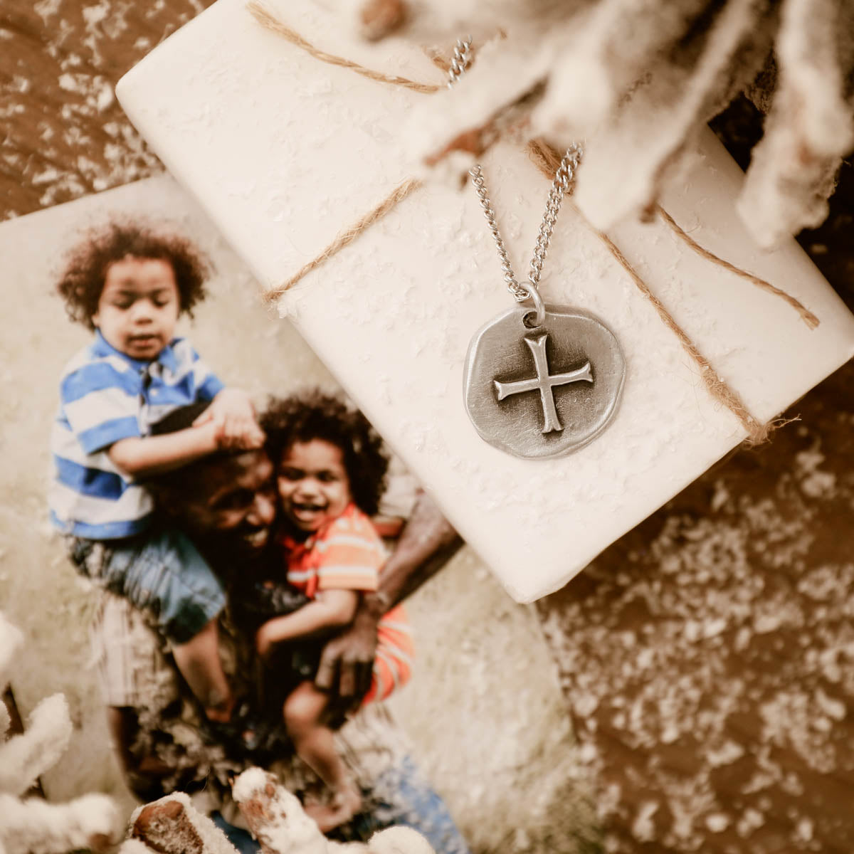 roman cross coin necklace on a white gift box