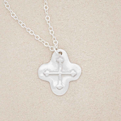 sterling silver shining light cross necklace on beige background